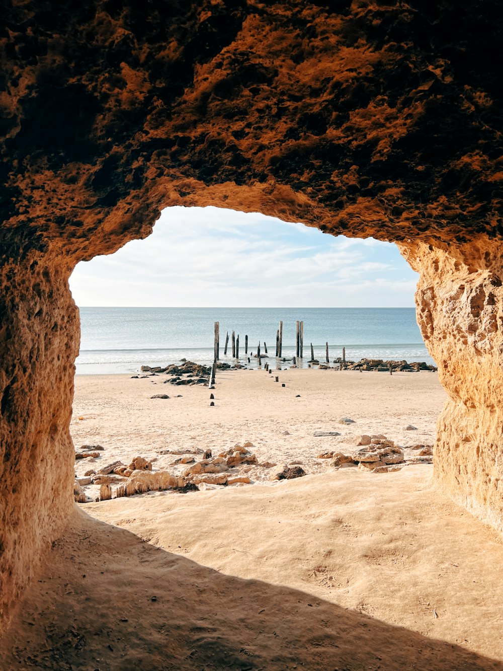 a view of a beach through a cave