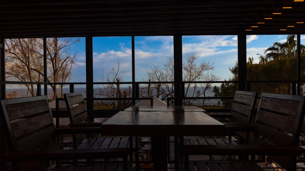 a wooden table sitting in front of a large window