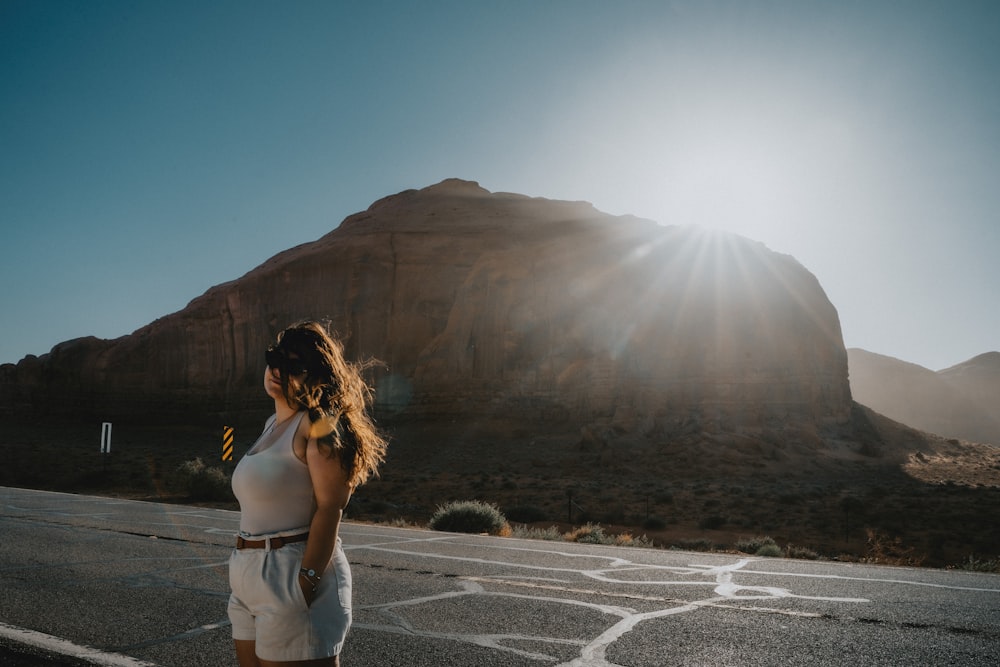 a woman standing in the middle of a road