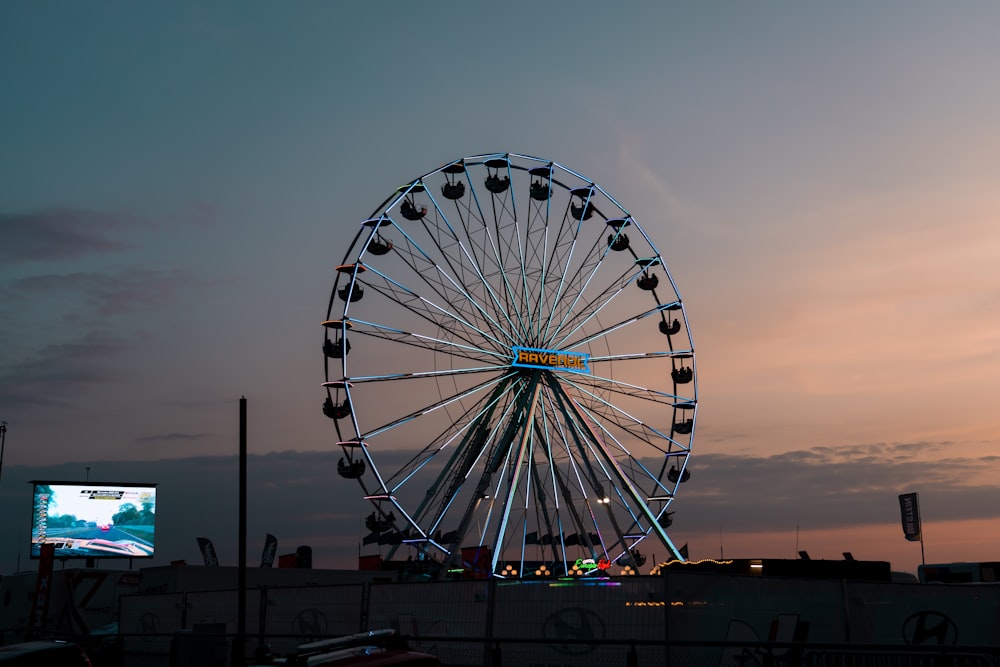 a large ferris wheel sitting next to a large screen