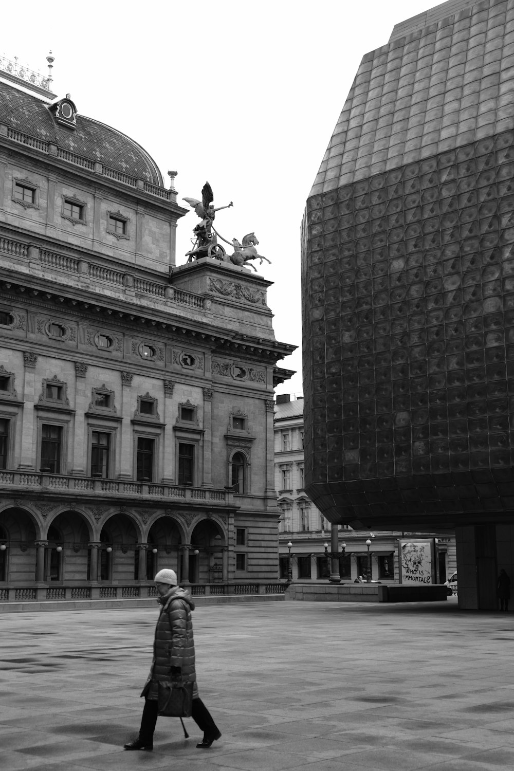 una persona caminando frente a un edificio grande