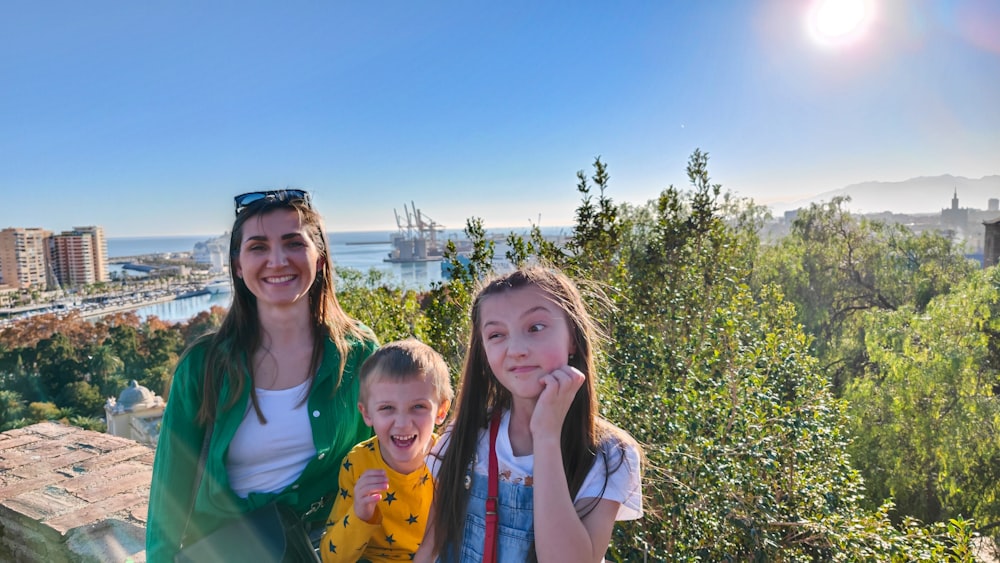 two girls and a girl are standing on a hill