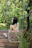 a woman sitting on a swing in the woods