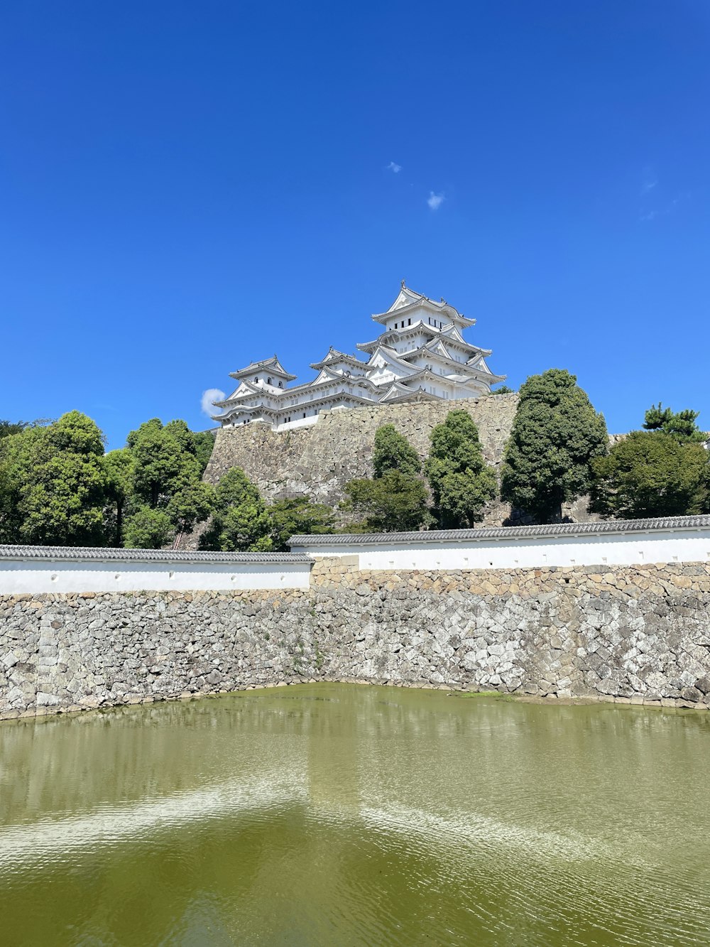 a large building sitting on top of a hill next to a body of water