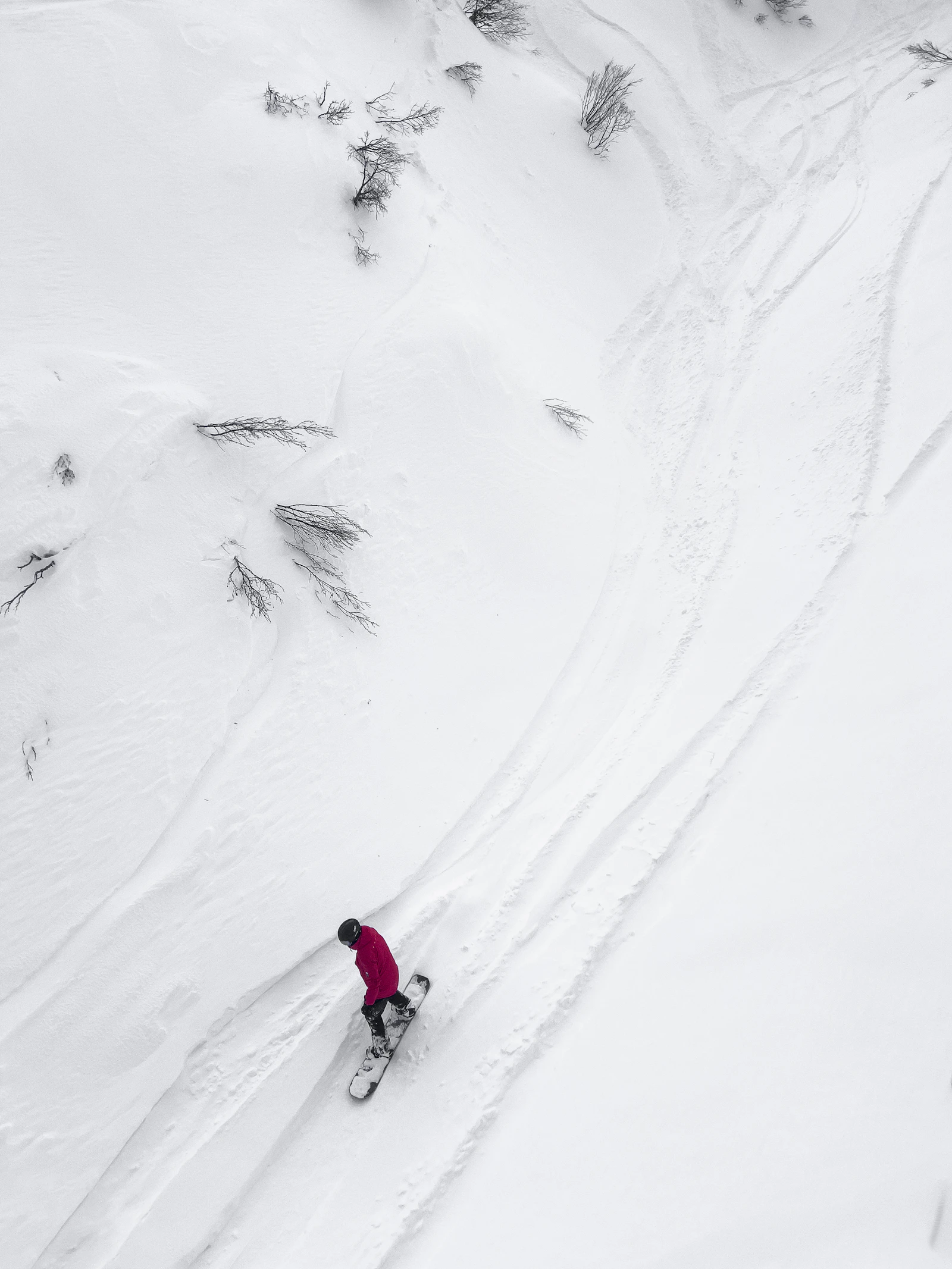 Snowboarder riding down a snow covered slope
