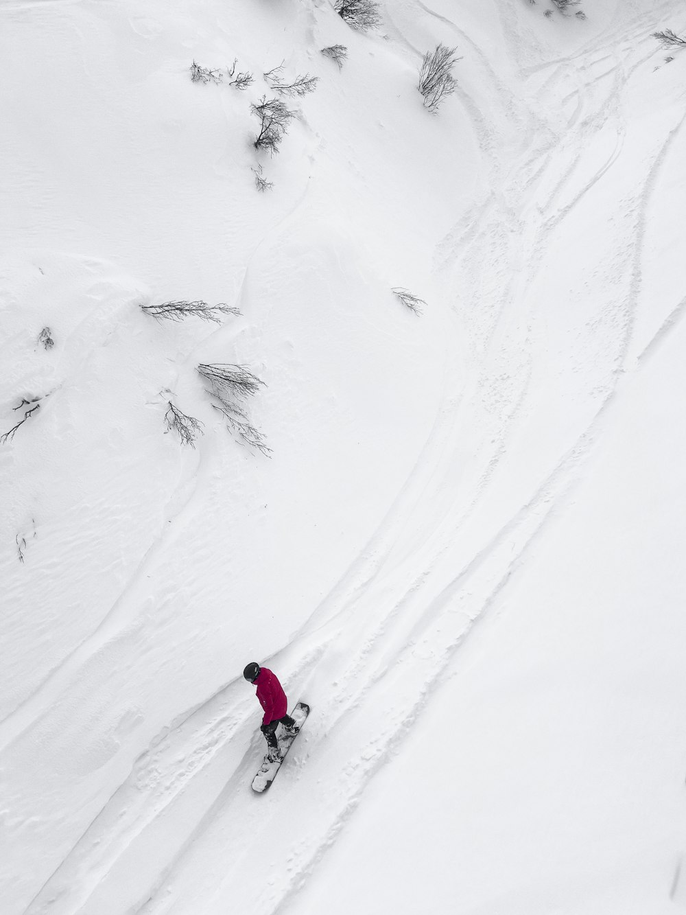 a person riding a snowboard down a snow covered slope