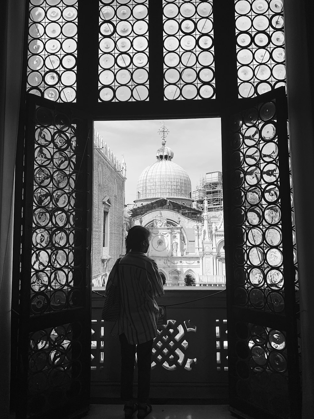 a person looking out a window at a building