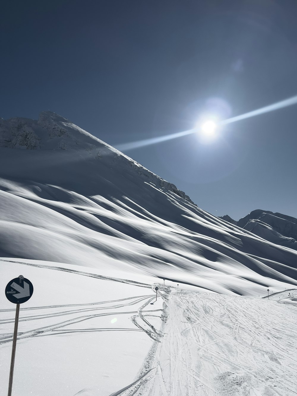 the sun is shining over a snowy mountain