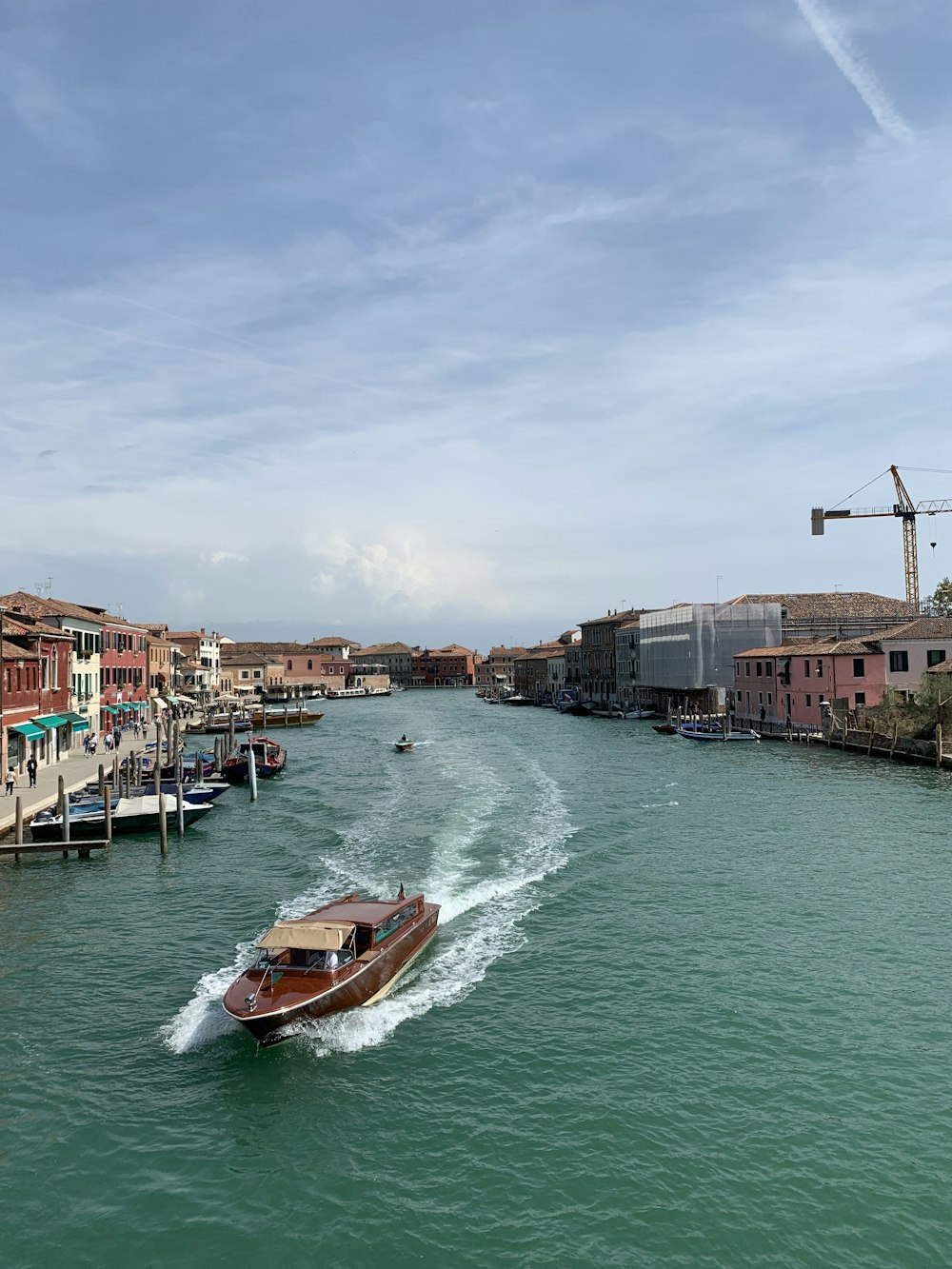 a boat traveling down a river next to buildings