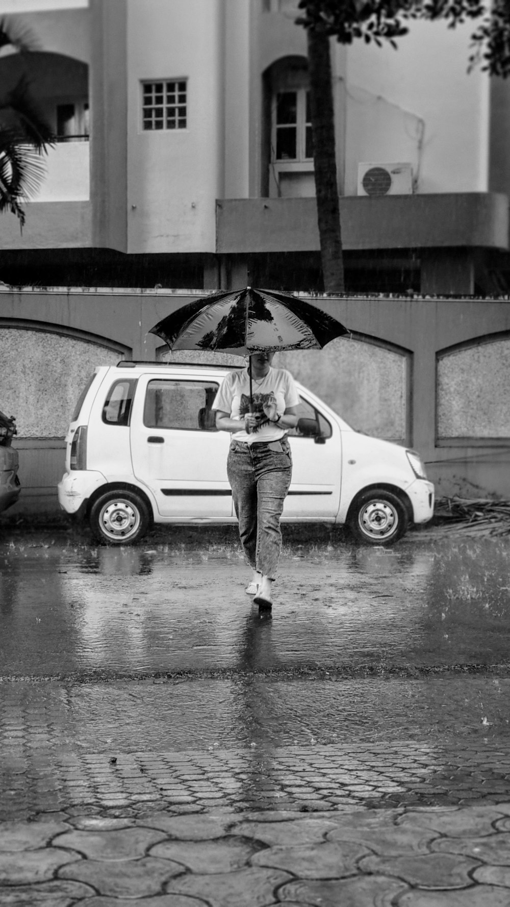 a black and white photo of a person holding an umbrella