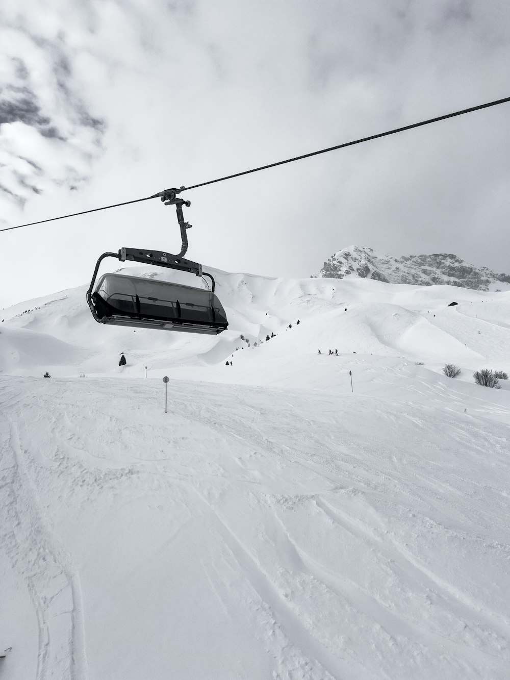 a ski lift going up the side of a snow covered mountain