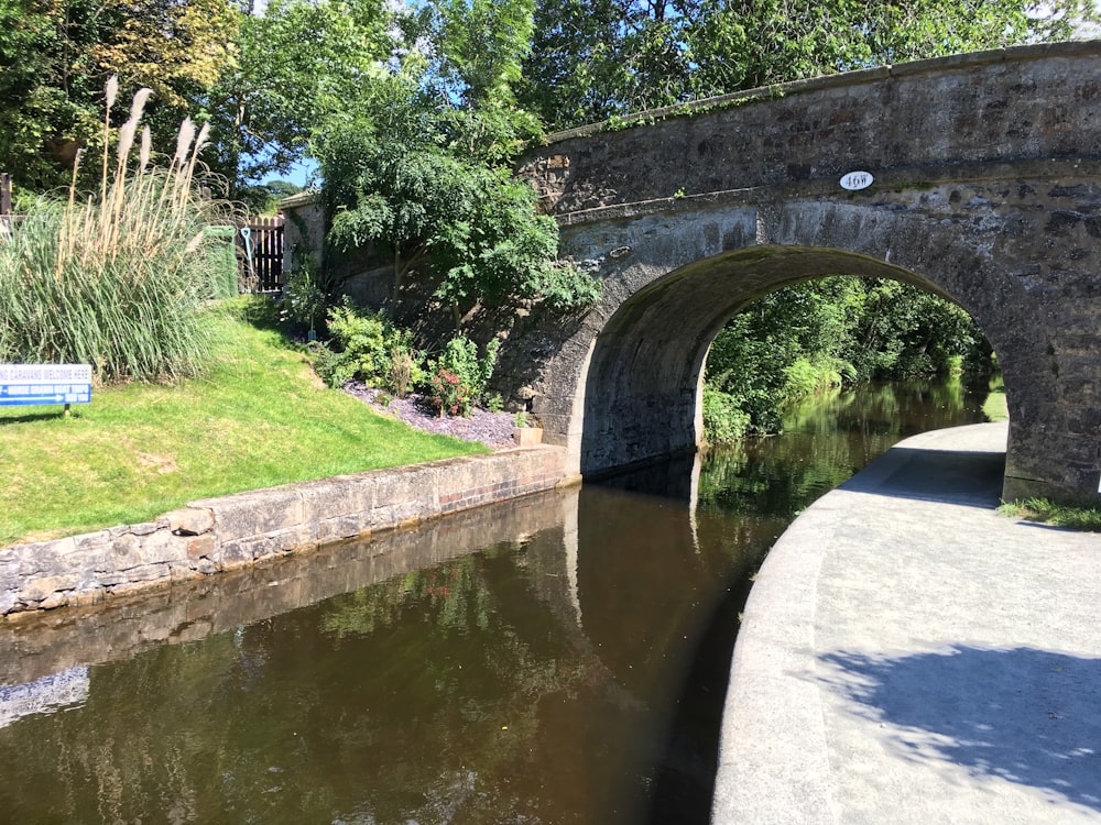 a bridge over a river with a bench in the foreground