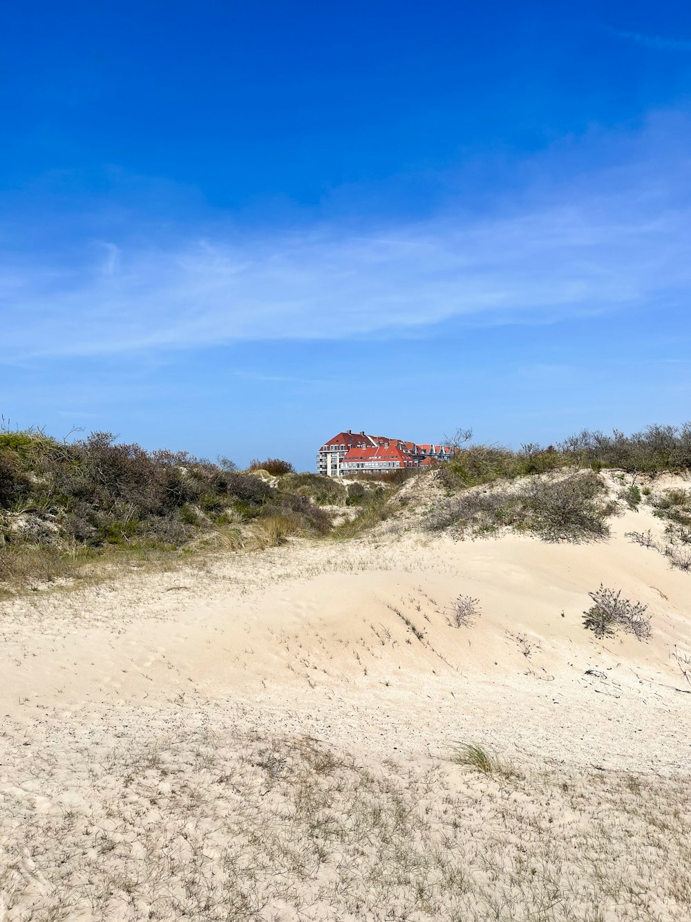 a house on a hill with a blue sky in the background