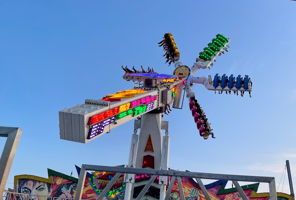 a carnival ride with colorful rides and a blue sky