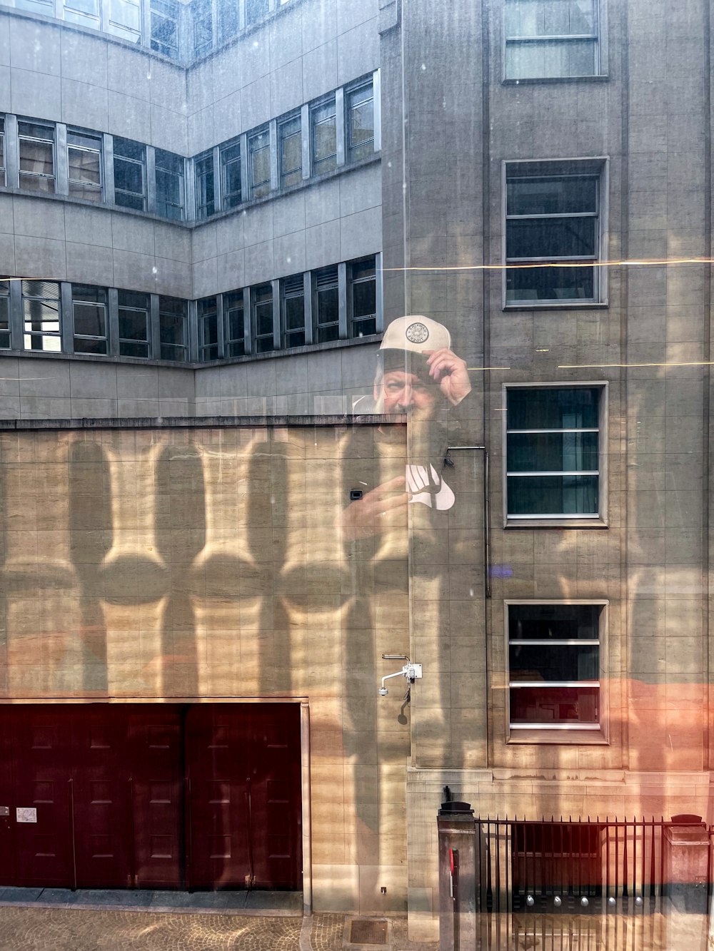 a reflection of a man in a window of a building