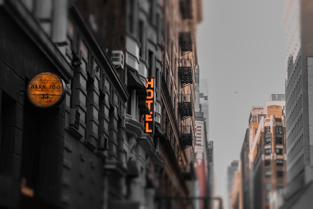 a city street with tall buildings and a neon sign