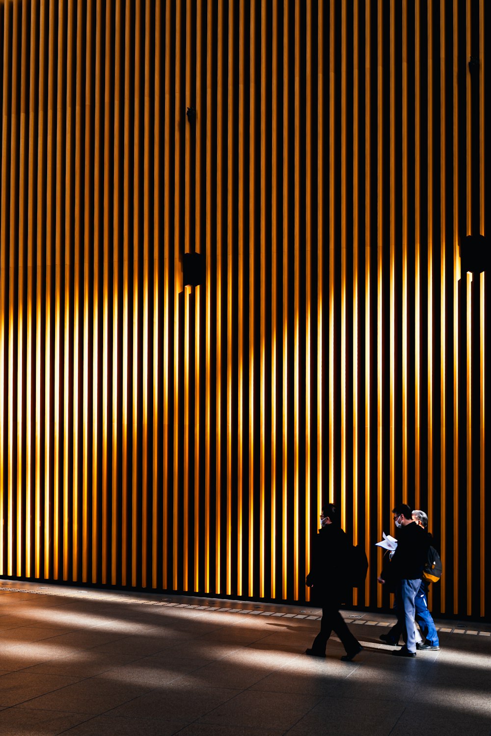 a couple of people walking past a tall building