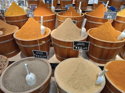 a bunch of buckets filled with different types of spices