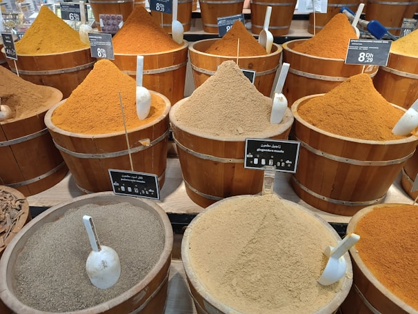 a bunch of buckets filled with different types of spices