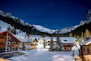 a night time view of a ski resort in the mountains