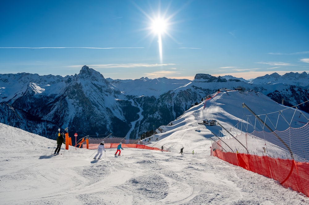 a group of people riding skis on top of a snow covered slope