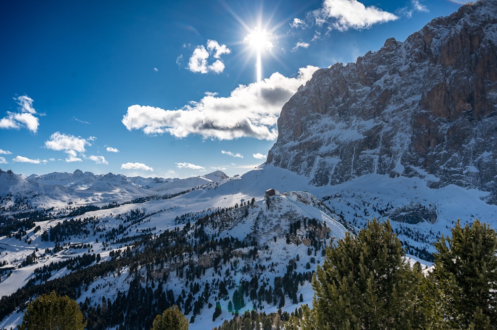 the sun shines brightly over a snowy mountain range