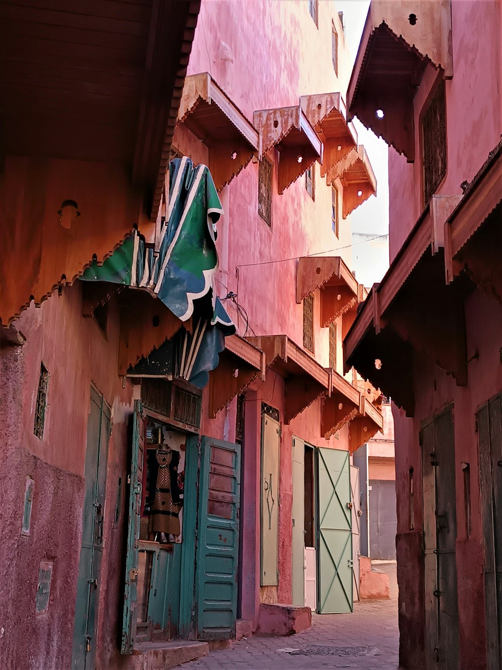 a narrow alley way with a clock on the wall