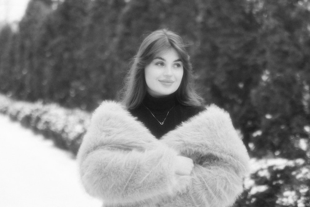 a woman in a fur coat standing in the snow