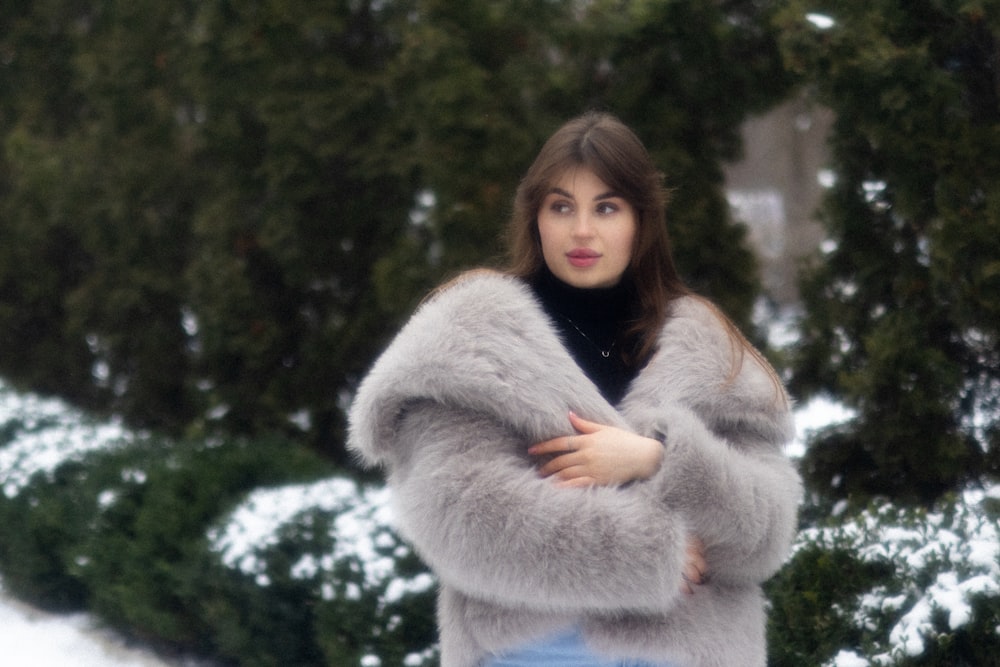 a woman in a fur coat standing in the snow