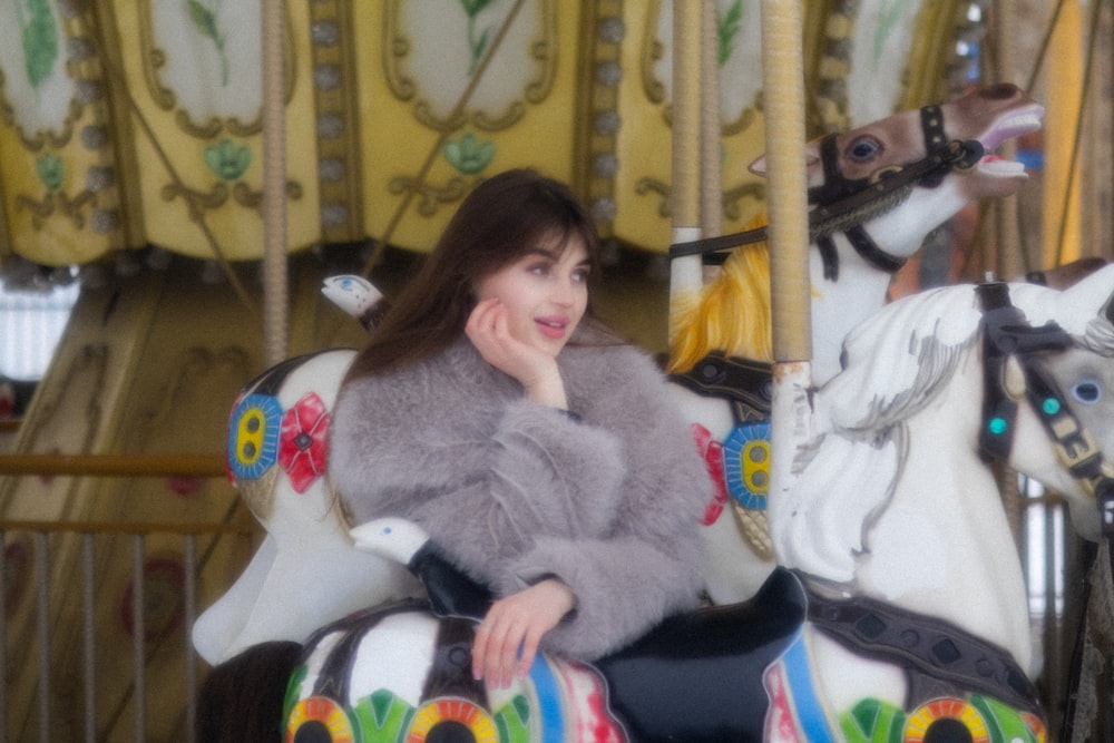 a woman is sitting on a merry go round