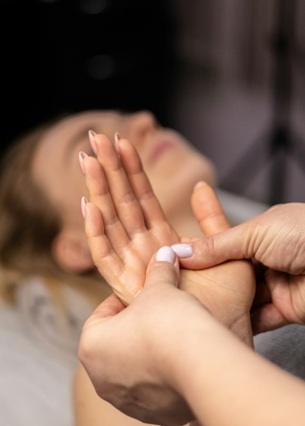 a woman laying on a bed with her hands together