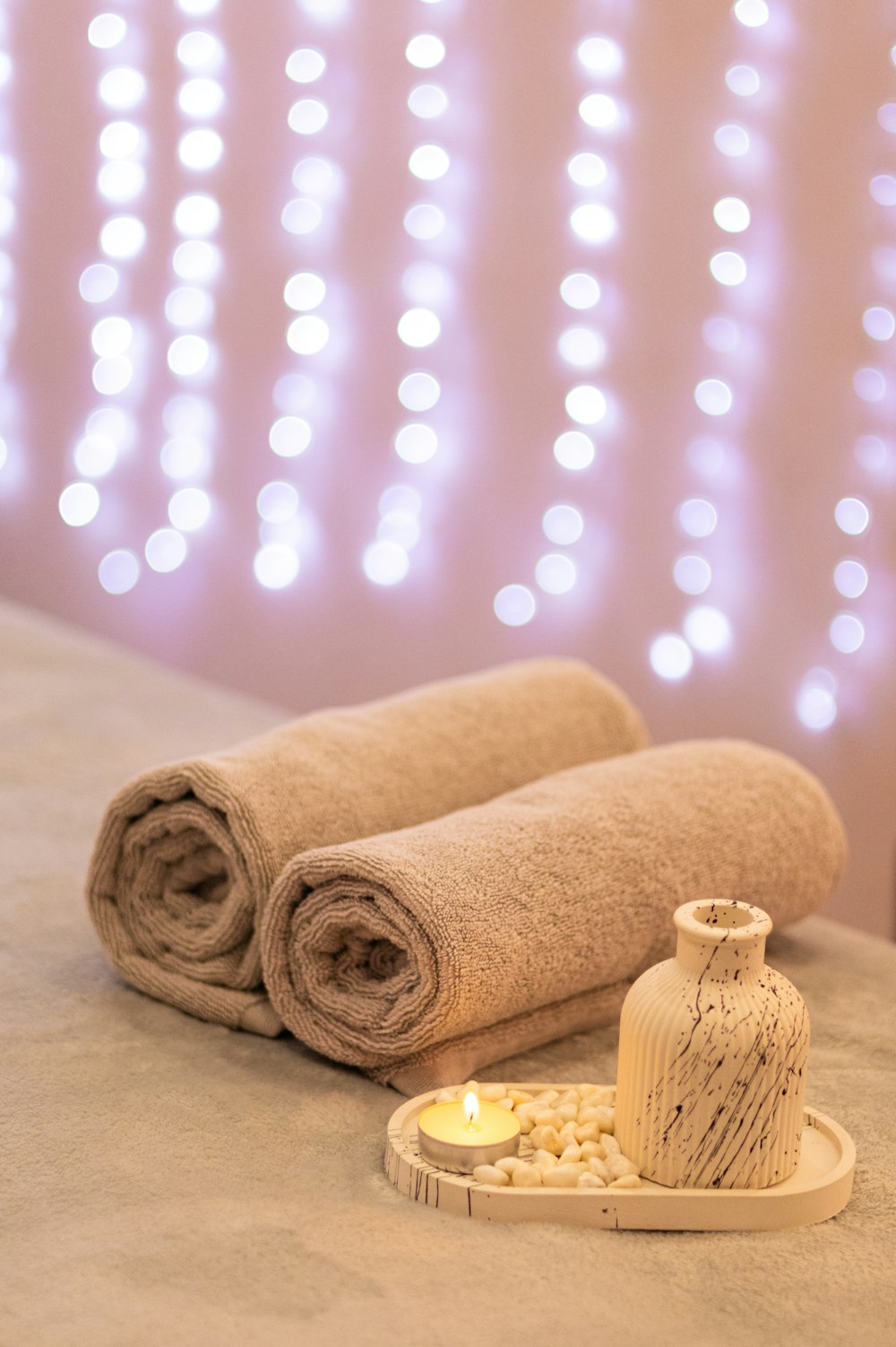 a couple of rolled up towels sitting on top of a bed