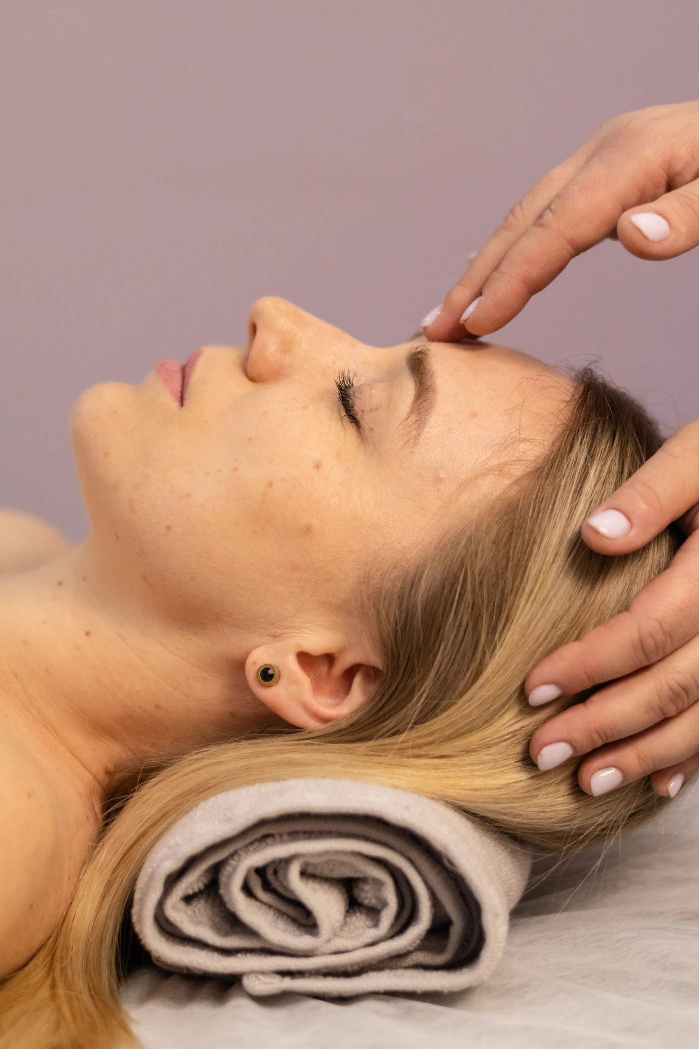 Woman receiving a gentle facial massage, representing the calming touch-based massage step of a Sensitive Skin Calming Facial session