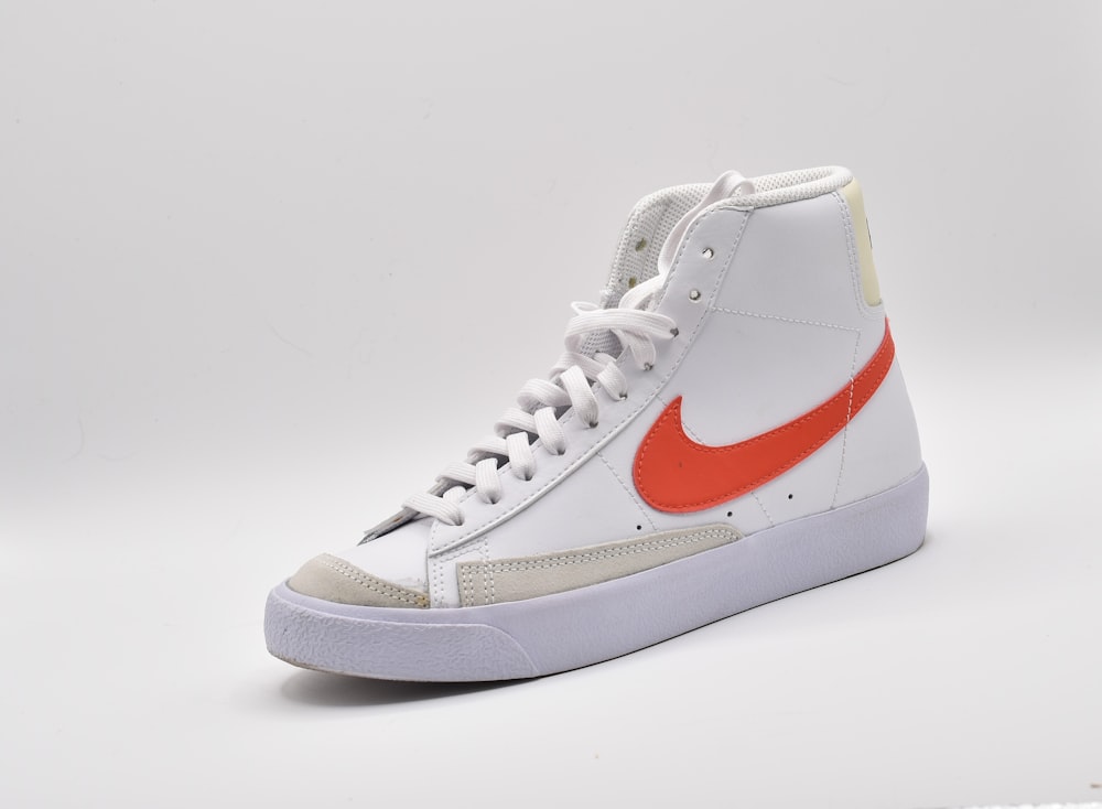 a pair of white and red sneakers on a white background