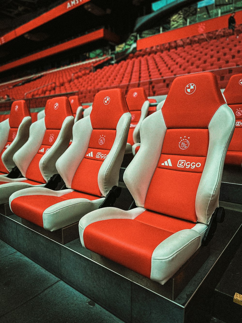 una fila de asientos rojos y blancos en un estadio