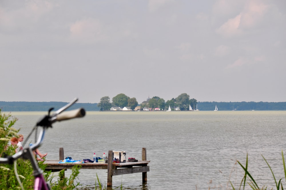 a bicycle parked on a dock next to a body of water