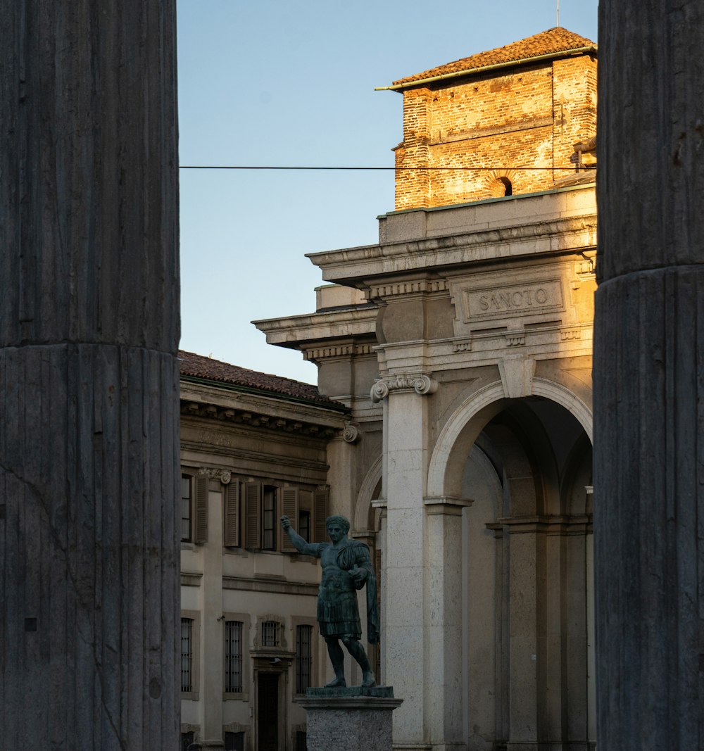 a statue of a man in front of a clock tower