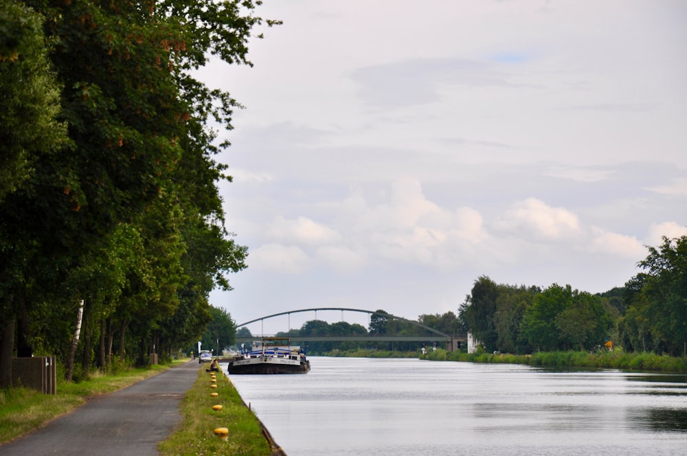 a boat traveling down a river next to a bridge