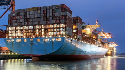 a large cargo ship in a harbor at night
