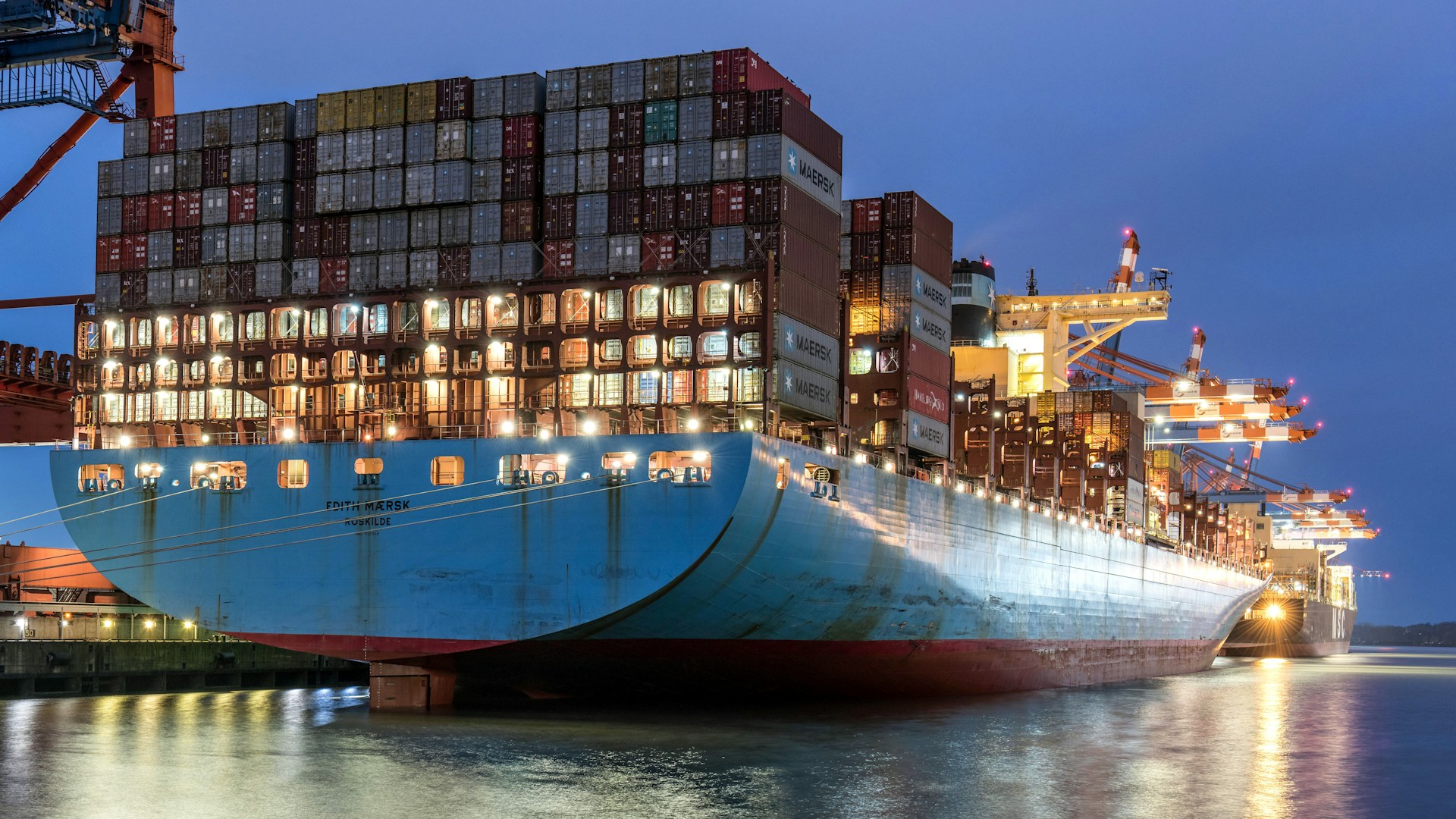 a large cargo ship in a harbor at night