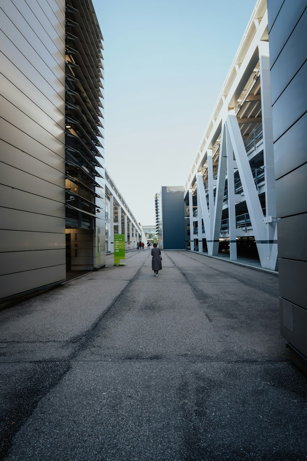 eine Person, die eine Straße neben hohen Gebäuden entlanggeht