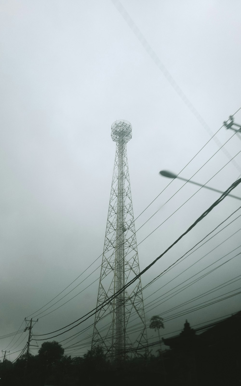 a tall tower with power lines above it