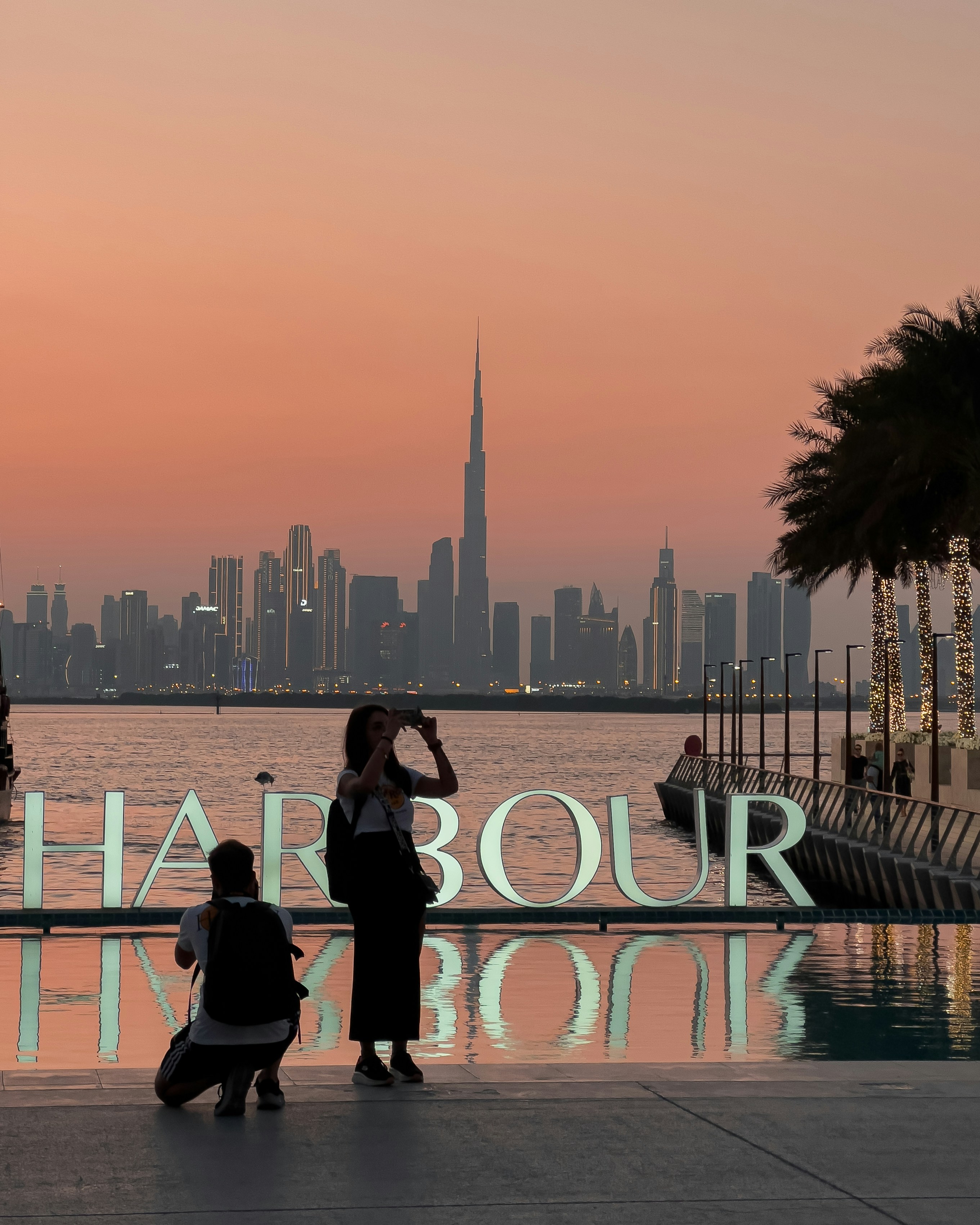 a couple of people standing next to a body of water