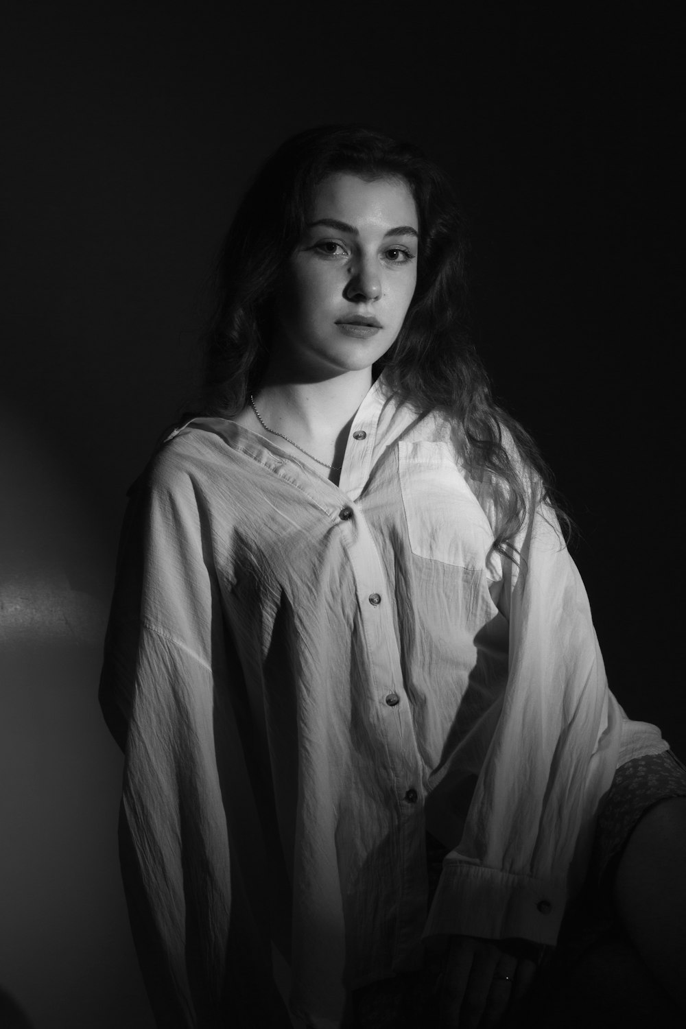 a black and white photo of a woman in a shirt