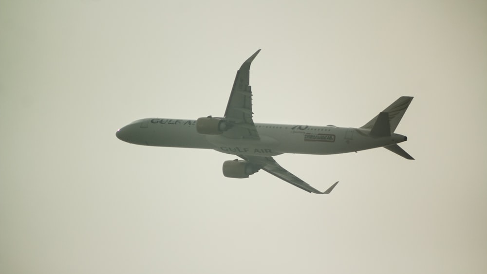 an airplane is flying in the sky on a cloudy day