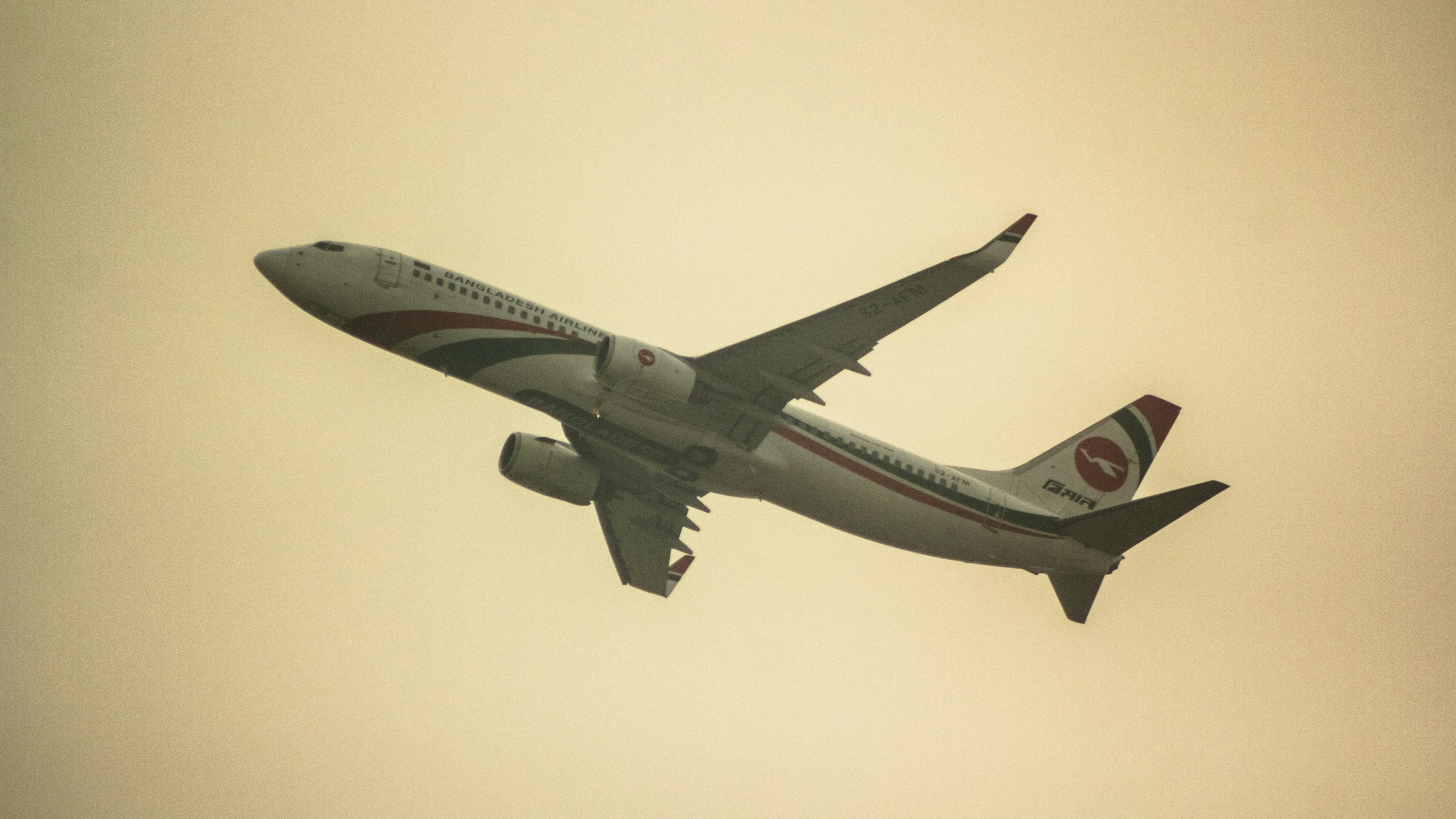 a large jetliner flying through a cloudy sky, Biman Bangladesh Airlines B737