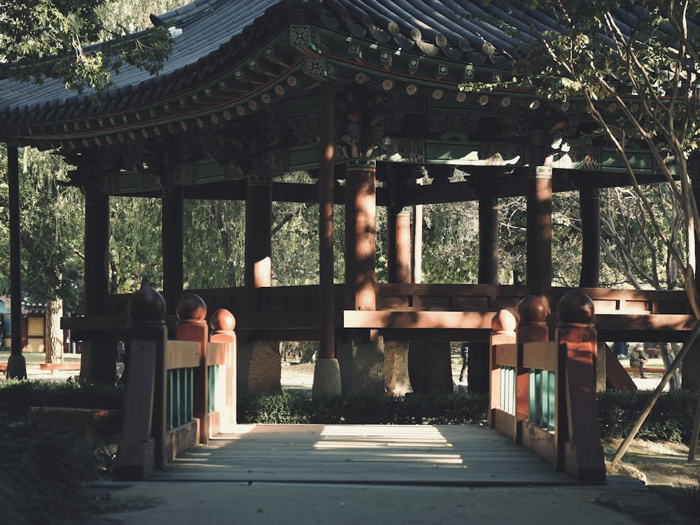 a gazebo in a park with trees in the background