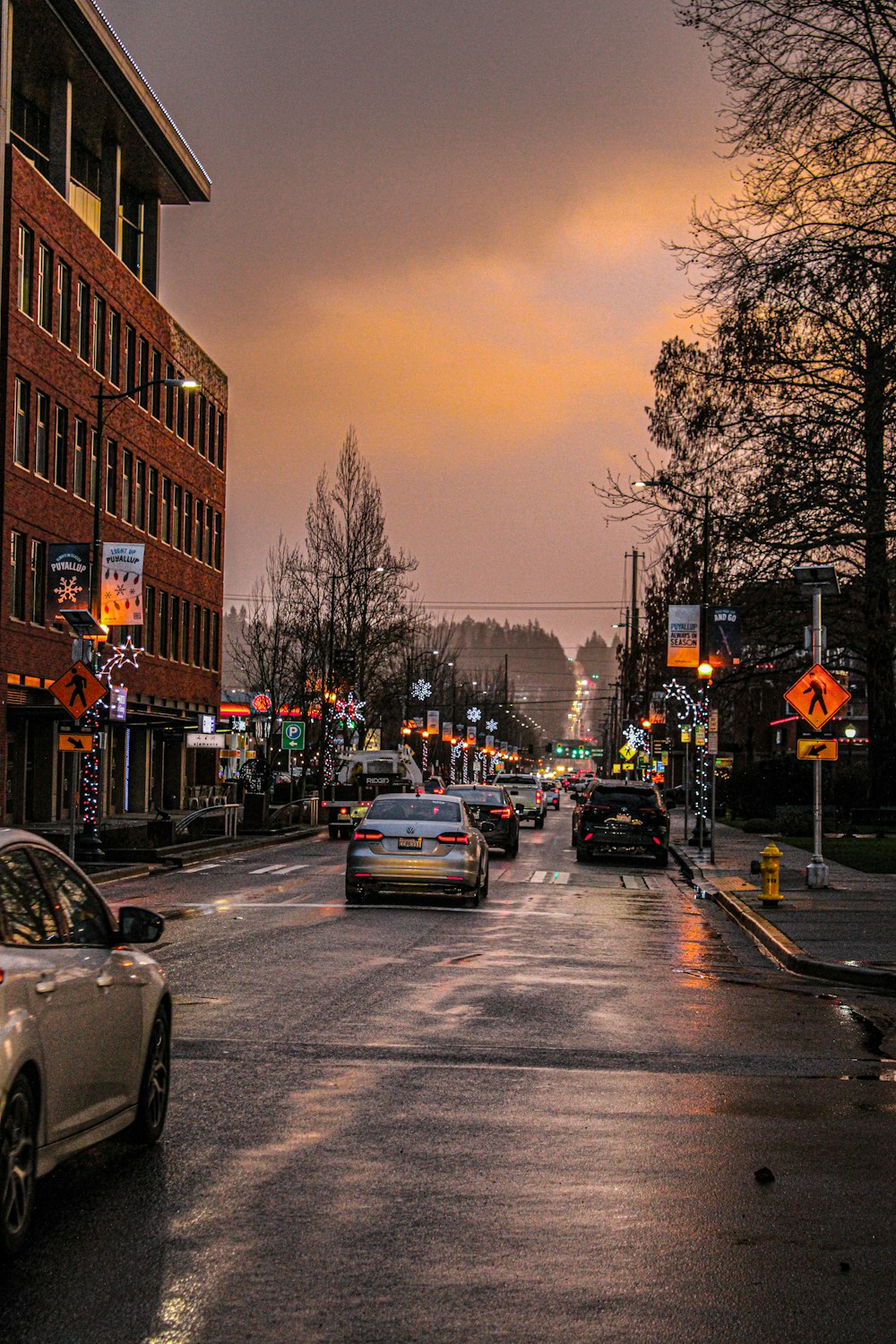 a city street filled with lots of traffic under a cloudy sky