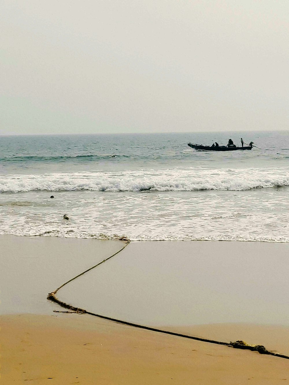a boat in the ocean with a rope in the foreground