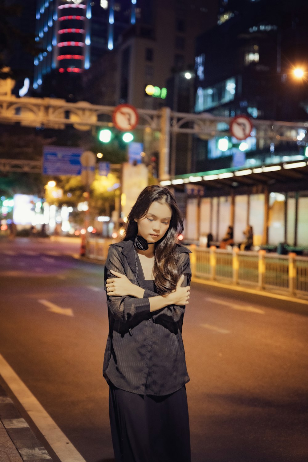 a woman standing in the middle of a street at night